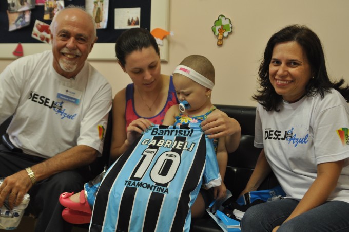 O pai da linda menina Gabrieli, Norival, nos escreveu. Sua linda e querida filha Gabrieli que faz tratamento de saúde é uma gremista fanática. Queria ganhar um uniforme completo do Grêmio. Em Porto Alegre acionamos a voluntária Lize Cappellari que juntamente com seu namorado Rafael adquiriram a camiseta numa das lojas do Grêmio. Como iria passar a semana na região de São Sepé onde mora a familia de Gabrieli aproveitou para levar em mãos o presente juntamente com o Cônsul do Grêmio na cidade Luiz Otávio Gazen. A corrente do bem se formou novamente, um cada um faz um pouco e esse pouco se transforma numa ação grandiosa para essa linda garotinha.  