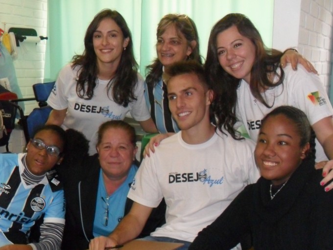 As meninas Clara e Ilcamare estudam numa turma especial do Colégio Cônego Paulo de Nadal.Ambas muito gremistas que são queriam ganhar um uniforme do Grêmio e conhecer o seu ídolo, o zagueiro Bressan. Fomos até à escola e levamos o Bressan que com toda sua simpatia e generosidade distribuiu sorrisos, autógrafos e respondeu a todas as perguntas da turma que fez uma festa especial para o atleta.As voluntárias Fabíola Rosa e Emanueelle Censi levaram as camisetas. Foi uma manhã de muita festa.