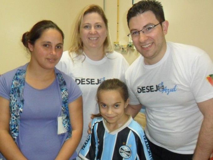 Paola tem 13 anos e faz tratamento no Instituto de Cardiologia. Nunca tinha recebido uma camiseta do Grêmio. Pois além da camiseta personalizada com seu nome a menina recebeu um uniforme completo dos voluntários Melissa e André Fávero. 