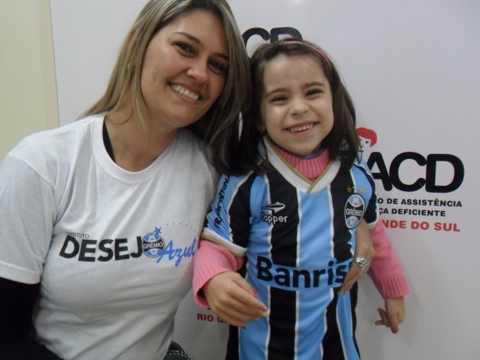 Fernanda tem 5 anos e faz tratamento na AACD. Esperta e alegre é uma criança iluminada. Queria muito ganhar seu uniforme completo do Grêmio para mostrar para o seu pai, gremistão fanático. Logo que recebeu o presente da voluntária Luciana Duarte tratou de colocar o uniforme completo e saiu toda orgulhosa pelos corredores da Instituição.