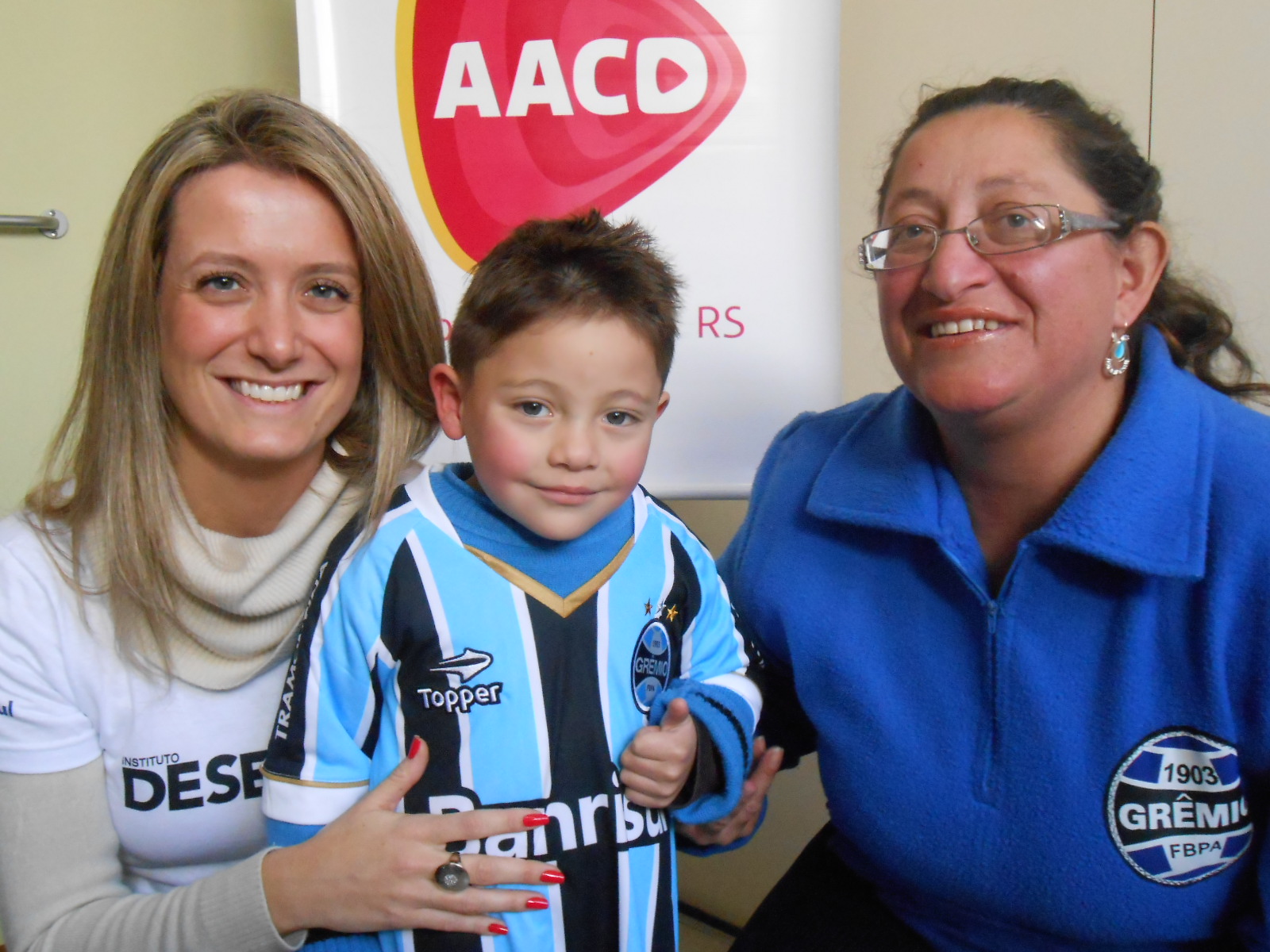 Carlos Alexandre tem 4 anos e faz tratamento na AACD. Tem tudo que diz respeito ao Grêmio. Chinelo, tênis, abrigo, só faltava mesmo um uniforme novo com uma camiseta personalizada com seu nome que a voluntária Daniela Guerreiro Keunecke ajudou a levar para alegria deste grande gremistinha e de sua mãe presenta na hora da ação