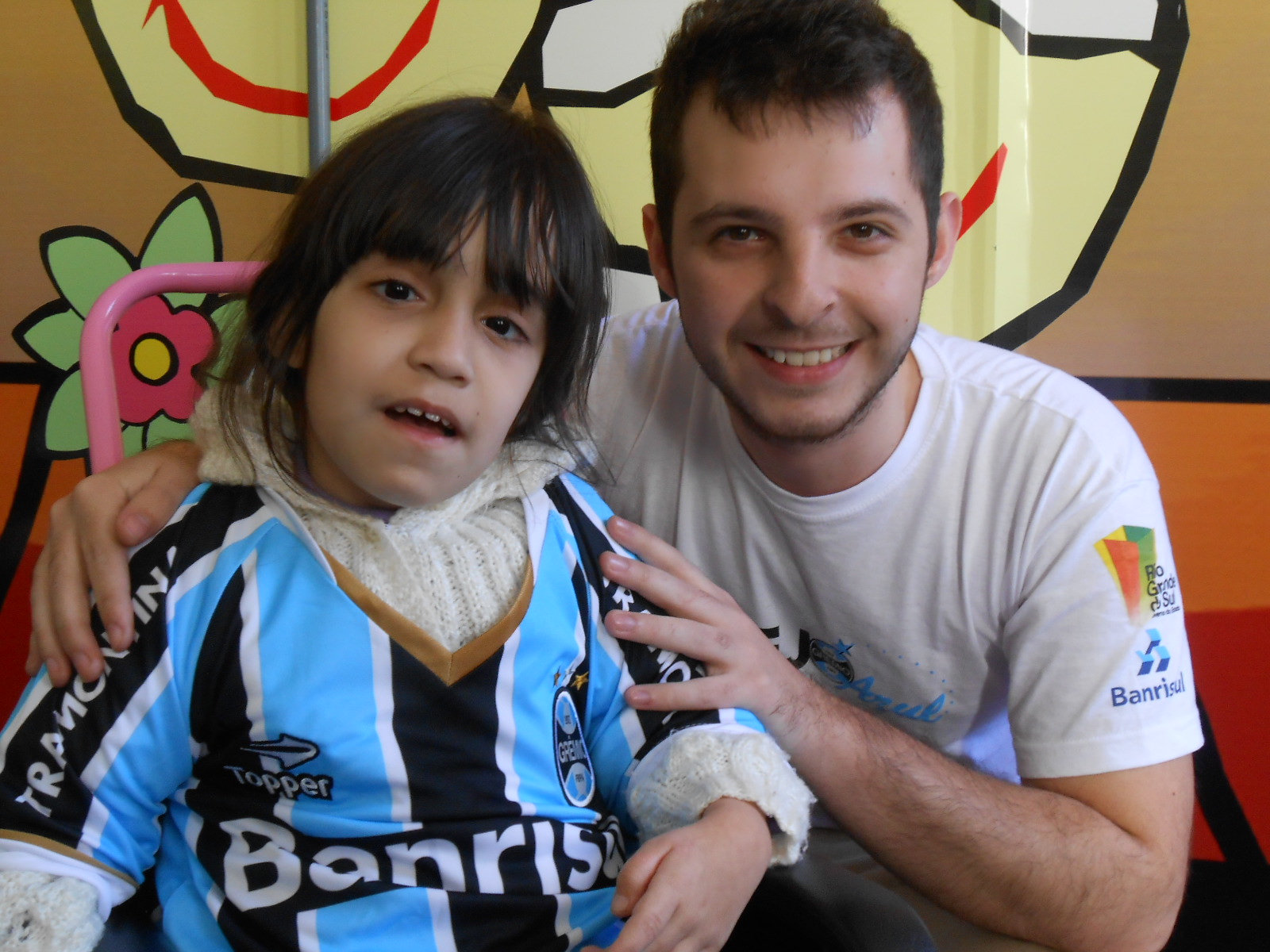 Tainá faz tratamento no Educandário São João Batista. Segundo sua mãe a última vez que havia ganho um uniforme do Grêmio foi logo que ela nasceu. Esperava como nunca que esse dia chegasse. E com a colaboração do voluntário Léo Fuhr levamos até a menina um kit completo com camiseta personalizada, calção e meia do Tricolor 
