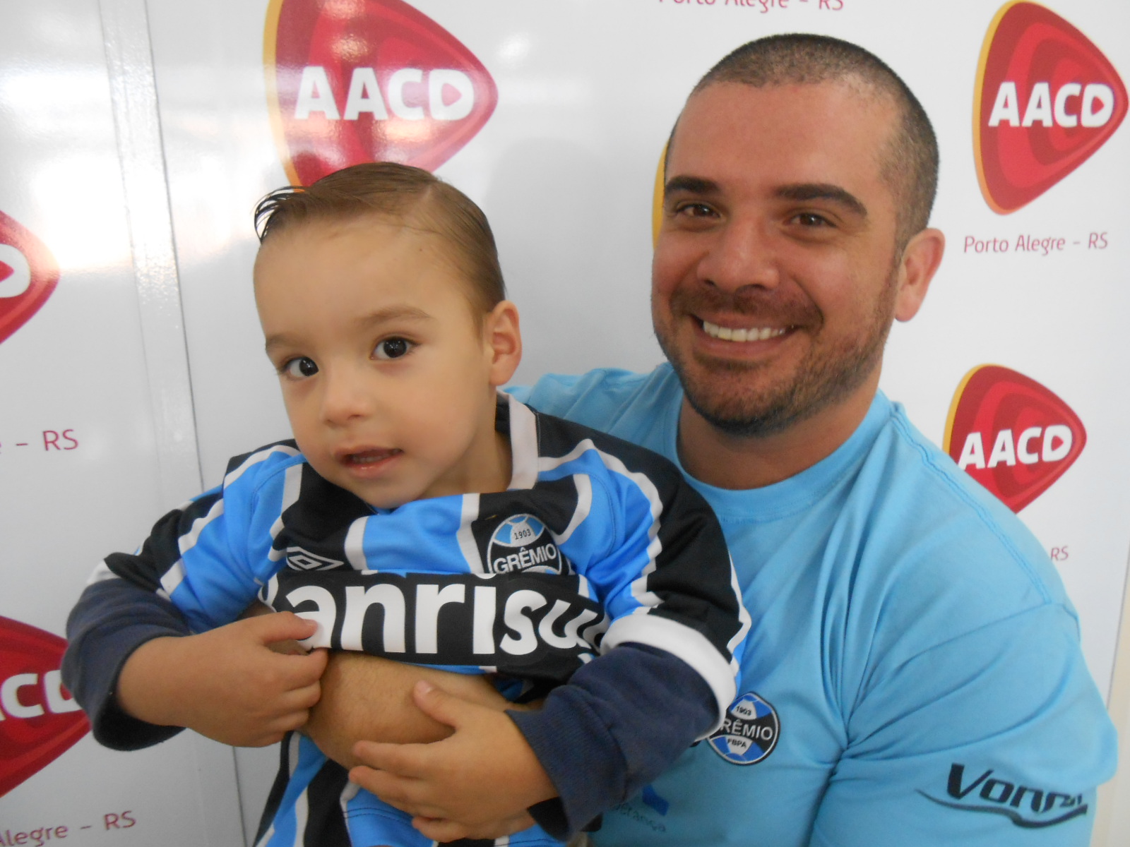 Bernardo tem três anos e faz tratamento na AACD. É fanático pelo Grêmio, assim como o pai e seu avó. Bernardo queria a camiseta oficial do Grêmio. E quem proporcionou esta alegria a este pequeno gremista foi o voluntário Marcus Pereira.