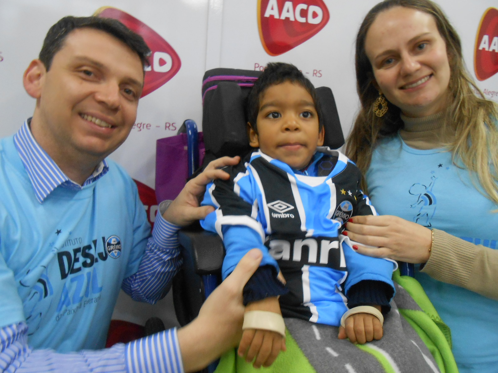 Guilherme faz tratamento ns AACD. Estava muito feliz no momento da ação pois ele iria ganhar sua camiseta oficial personalizada com seu nome dos voluntário Fabrício Lima e Juliana Muller Marcon.