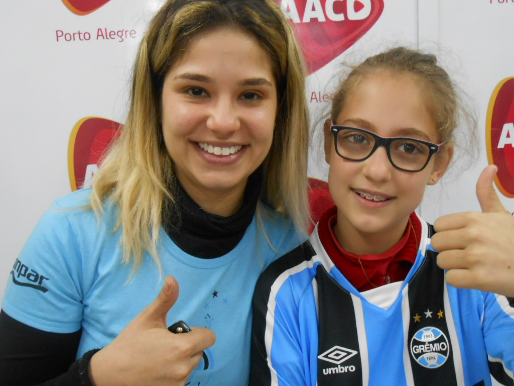 Desirée faz tratamento na AACD. Seu desejo além de ir a um jogo do Grêmio na Arena era ganhar uma camiseta tricolor com seu nome personalizado. E com a colaboraçao da voluntária Luiza Barbosa levamos até à menina este presentão azul.