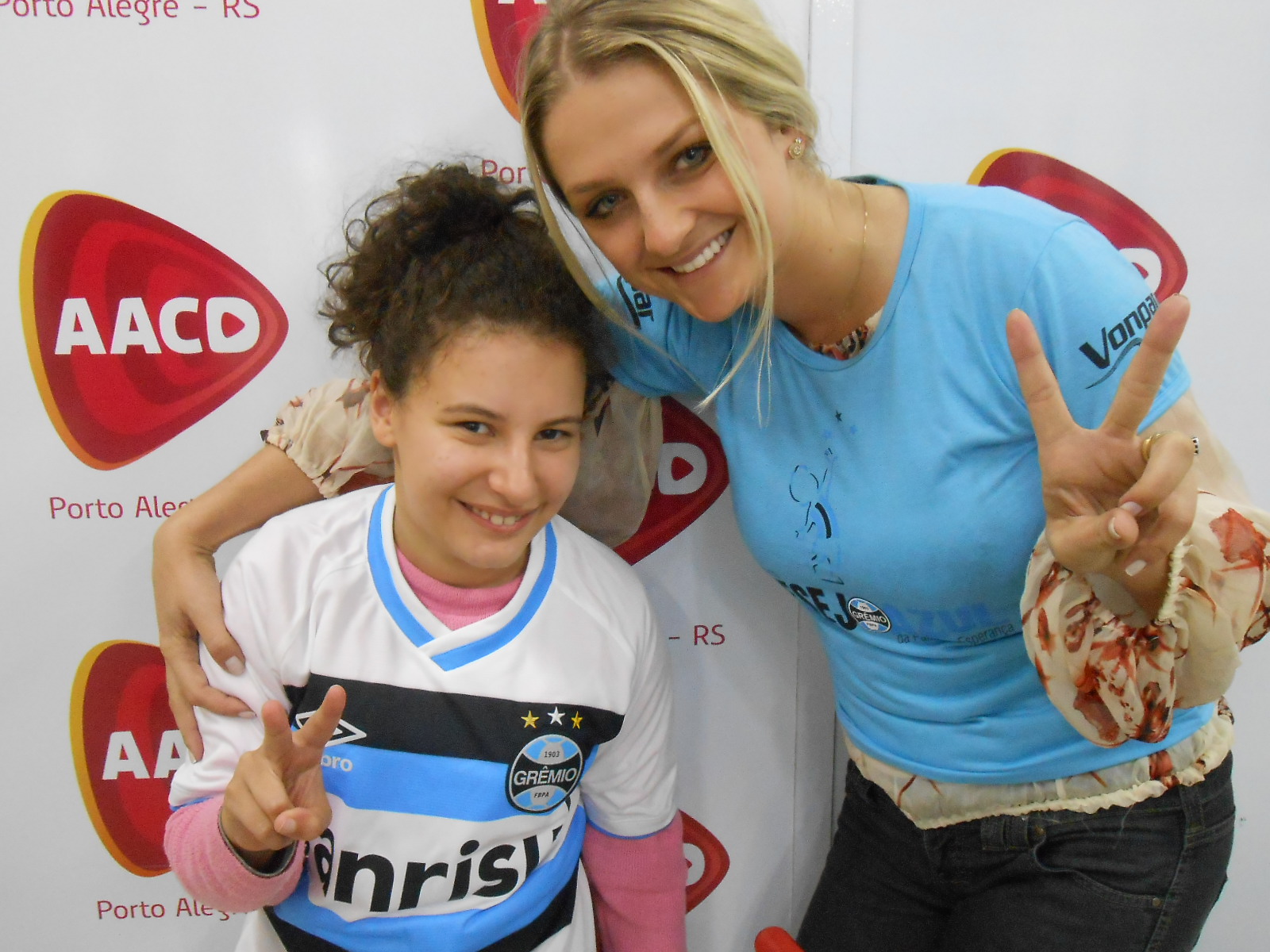 Alexandra faz tratamento na AACD. Estava muito feliz pois além de assistir a grande vitória do Tricolor ontem à noite , ganhou da voluntária Sofia Costa a camiseta do Grêmio, o mesmo modelo que o timão atuou no Mineirão. Na foto tanto ela como a voluntária Sofia Costa fizerem V da vitória e dos 2 x 0 