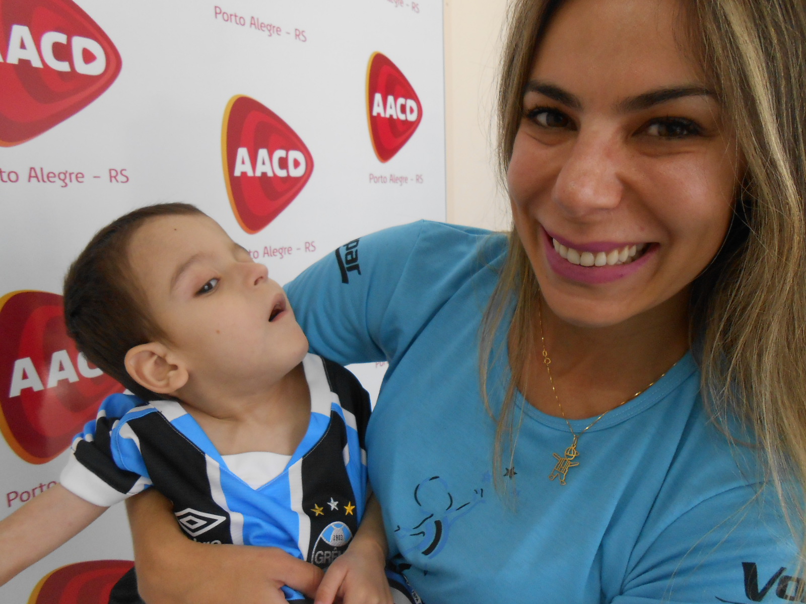 Eduardo tem 3 anos e faz tratamento na AACD. Foi o primeiro gremista a receber o manto tricolor já como pentacampeão. A cada dia ele apresenta progresso no seu tratamento e vai vencer como o Grêmio. A ação contou com a colaboração da voluntária Rita Brescovici.