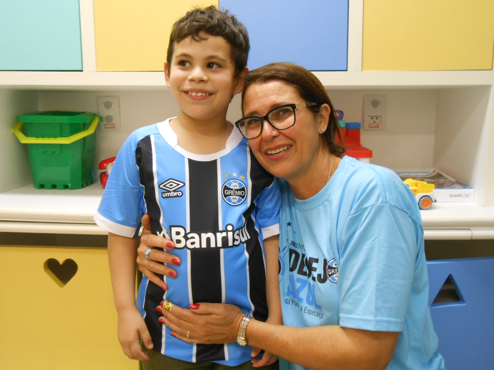 Rodrigo faz tratamento no Hospital Conceição. Três vezes por mês ele vai até ao hospital onde faz consultas e exames. Na última sexta foi diferente pois uma presentão azul o esperava. O menino ganhou das mãos da voluntária Suzana Ferreira da Cunha uma camiseta oficial do Grêmio.