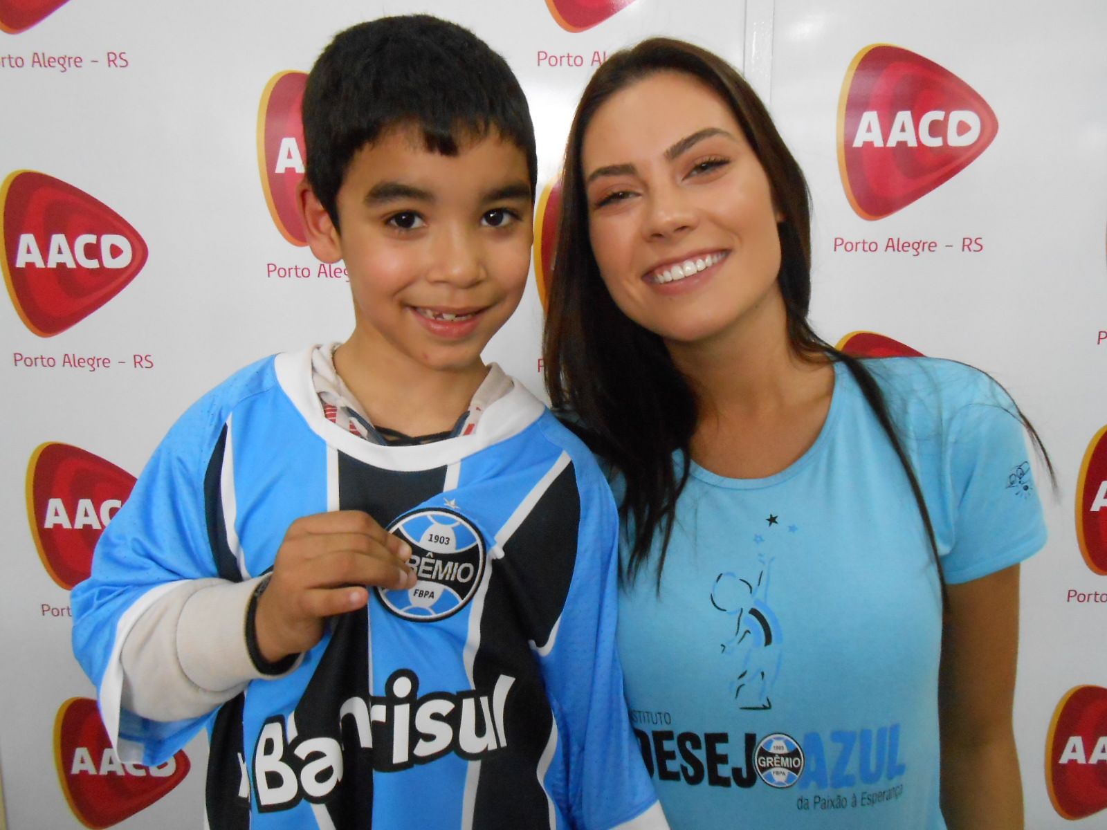 Alisson tem 7 anos e faz tratamento na AACD. O menino que mora em Viamão desejava e como desejava ganhar uma camiseta oficial do Grêmio. E para um tricolor tão querido e amado como o Alisson nada melhor que atual Miss RS Juliana Mueller para ser a voluntária. Uma ação em azul, preto e branco, com muito amor e solidariedade e bonita por natureza.