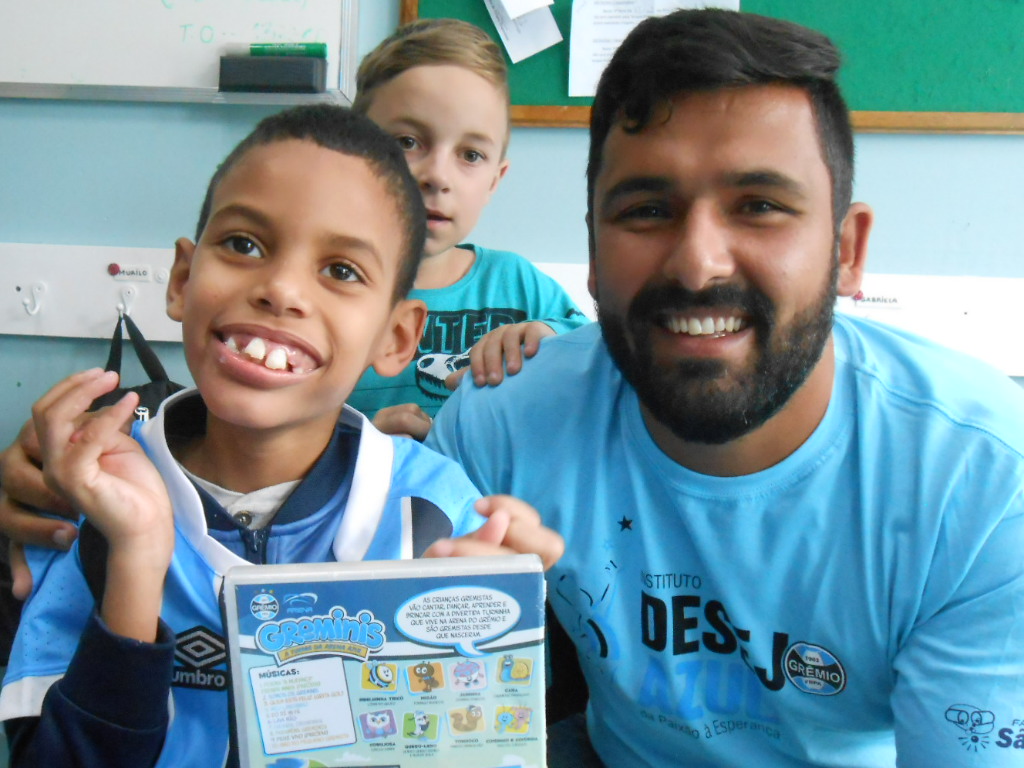 Murilo faz tratamento na Kinder. Começou desde cedo e hoje já apresenta vários avanços na saúde. Murilo é um gremistão e queria ganhar uma camiseta do Grêmio, algo que foi possível com a colaboração do voluntário Darlan Dias Pretinho.