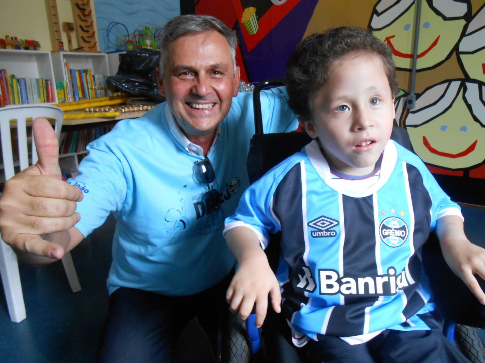 Orgulho é vestir a camiseta do Grêmio. A camiseta Tricampeã da América. Orgulho é estar entre os dois melhores times do planeta. E Natanael está orgulhoso com seu time e vestiu a camiseta do Grêmio dada pelo voluntário Luis Lima com muita alegria. Vamos Natanael, tu és um vitorioso como o Grêmio.