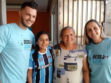 Maria Lúcia faz acompanhamento na APAE de Canoas . É uma querida gremista que não cabia em si de tanta felicidade ao receber o manto tricolor dos voluntários Tagiane Busanello e Matheus Dutra.