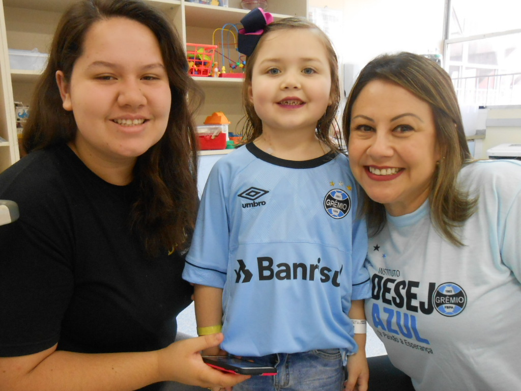 Nicoly está fazendo tratamento no Hospital de Clínicas, mais precisamente no Instituto do Câncer Infantil. A pequena gremista tinha uma camiseta do Grêmio, mas essa que se compra em camelô, falsificada. Pediu uma oficial e ganhou da voluntária Cristiane Azevedo a camiseta que vai ajudar e dar muita força no seu tratamento.